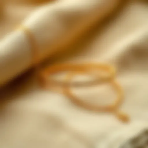 A stylish gold anklet extender elegantly displayed on a fabric surface.