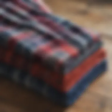 An arrangement of plaid flannel blankets in various colors on a rustic wooden surface