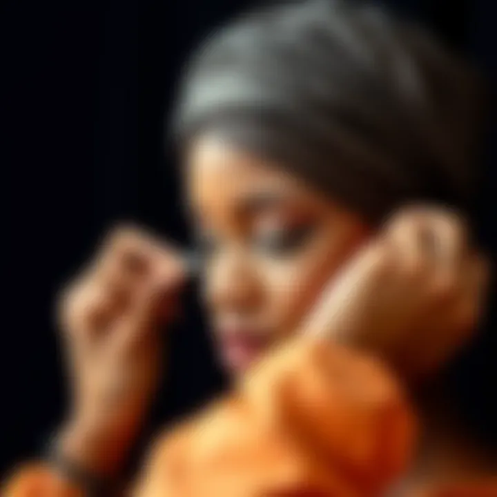 Close-up of a hand applying styling techniques to a satin bonnet head wrap.